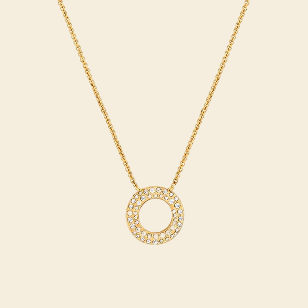 Gold necklace with a circular pendant on a white background