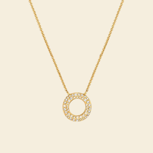 Gold necklace with a circular pendant on a white background