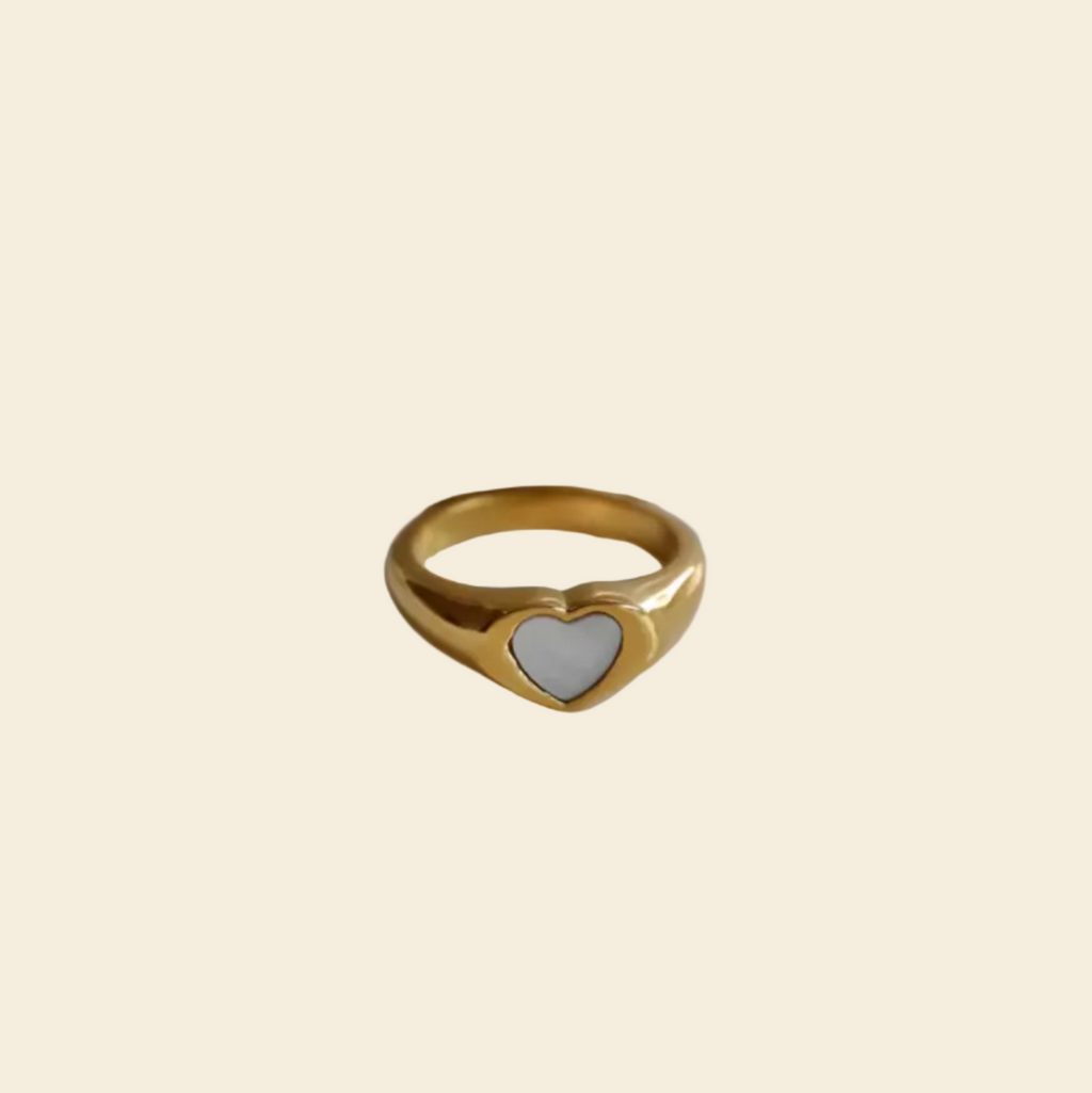 Gold ring on a white dish with a black background