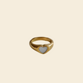 Gold ring on a white dish with a black background