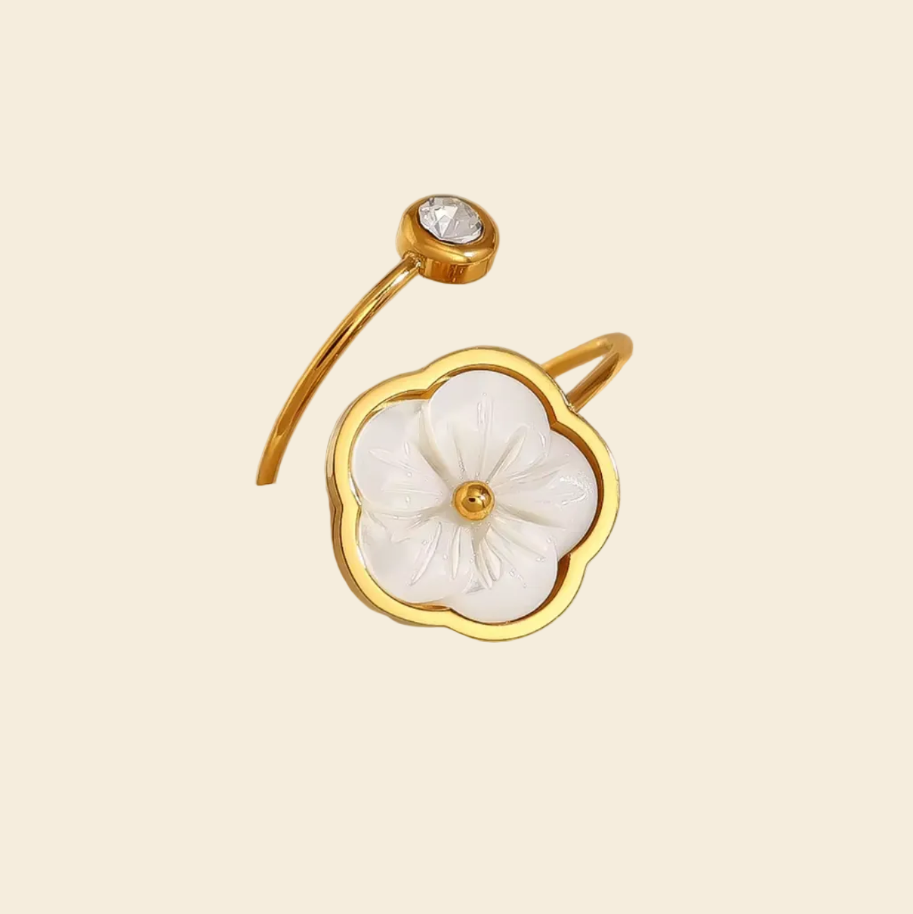 Gold ring with a floral design on a mannequin hand against a beige background