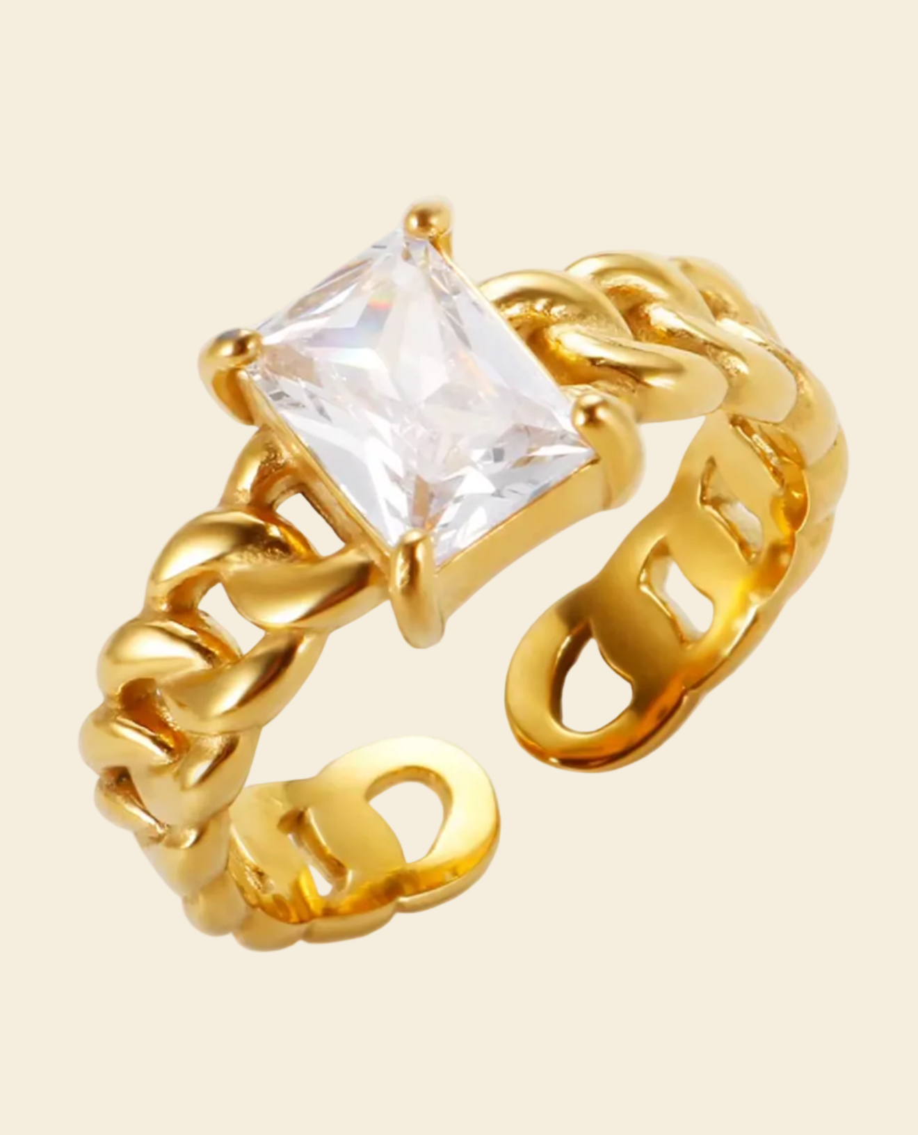Gold ring with a clear gemstone on a beige background