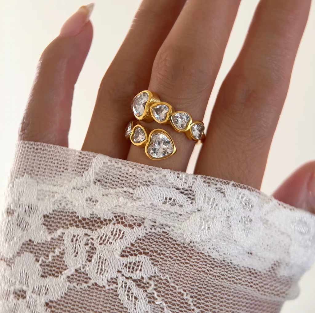 Gold ring with diamonds on a hand wearing a white lace glove